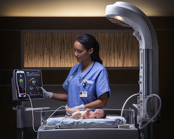 Clinician checking Root monitor attached to baby in the neonatal ICU