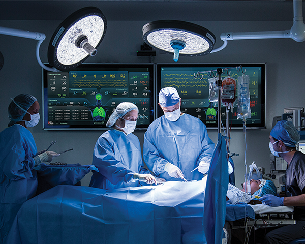Surgeon and medical team operating on patient with UniView display in the background